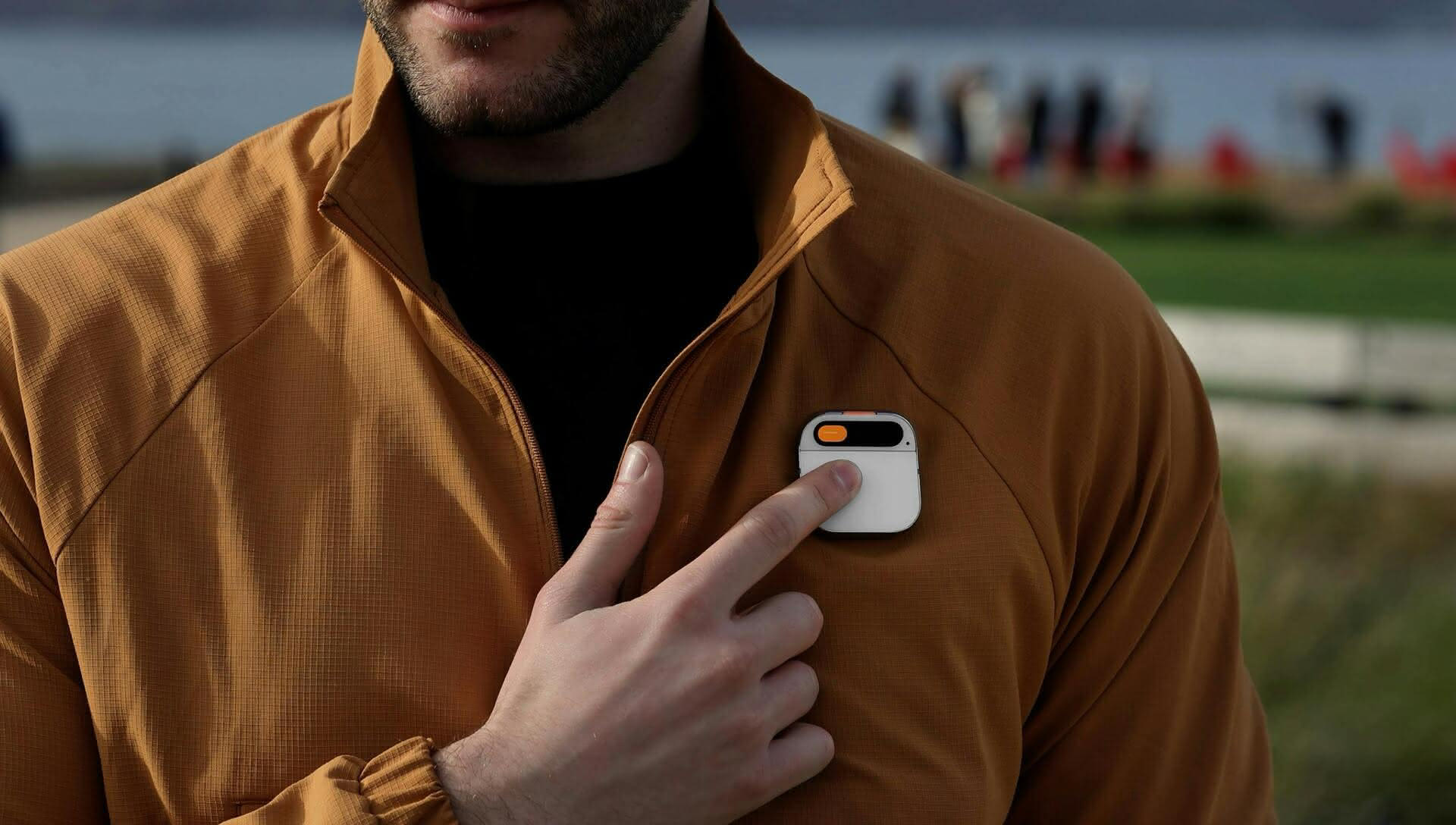 Humane AI Pin being worn by a man in a brown jacket